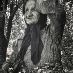 Black and white photo of old woman adjusting her headscarf