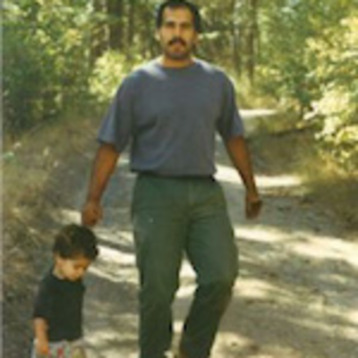 Mario J. Gonzales walking in woods with child