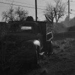 Black and white photo of old truck in sand