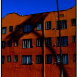 Photo of a terracotta apartment building in the evening.