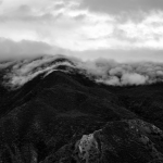 Black and white photo of low clouds over mountains