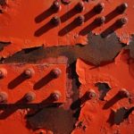 Photo of red wall with bolts painted over