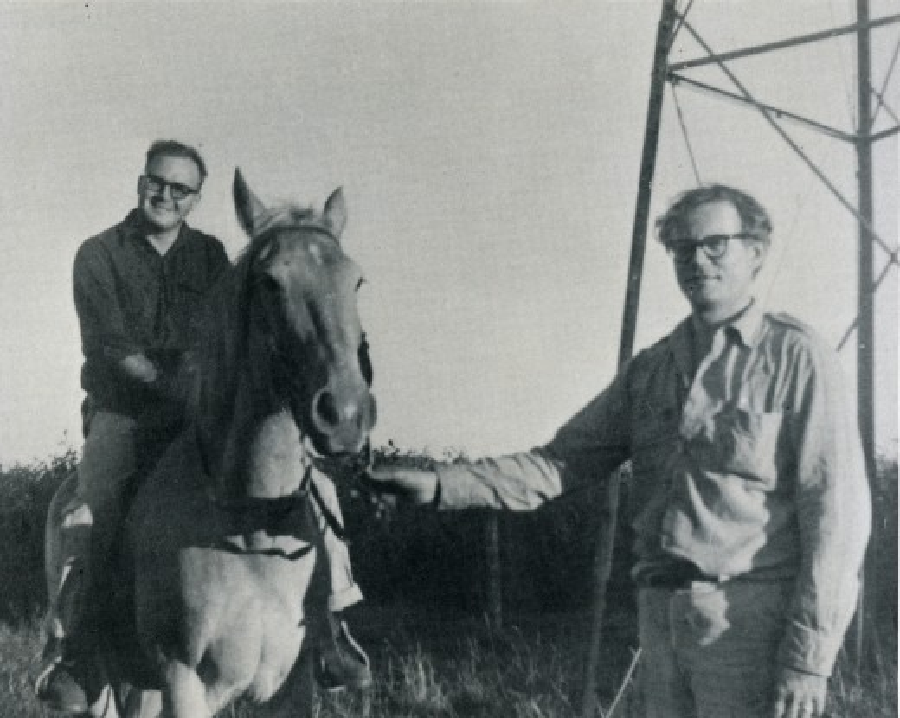 Black and white image of two men, one on a horse.