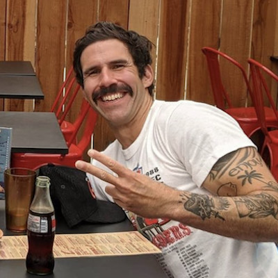 Photograph of author Patrick Holian in a white t-shirt