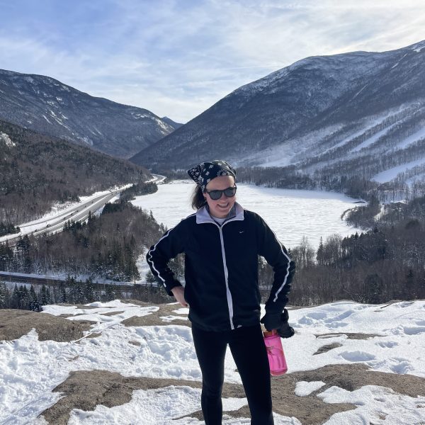 Photo of fiction editor E.C. Gannon in front of snowy mountain vista.